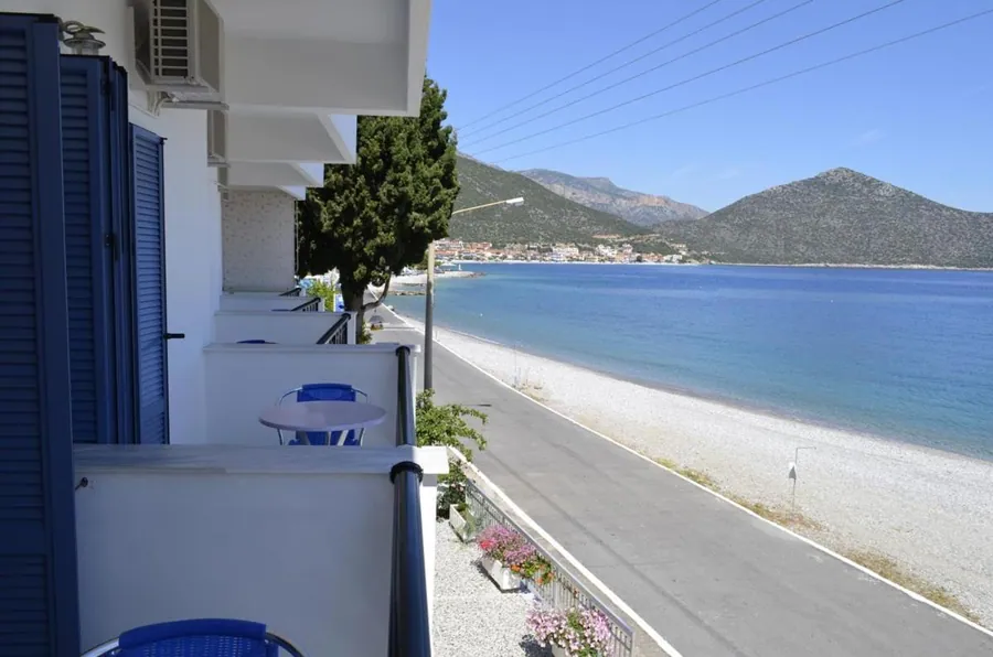 Μπαλκόνι με μπλε παντζούρια και ο παραλιακός δρόμος